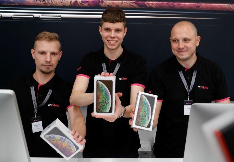 Employees pose for a picture during the launch of the new iPhone XS and XS Max sales at a shop in Moscow