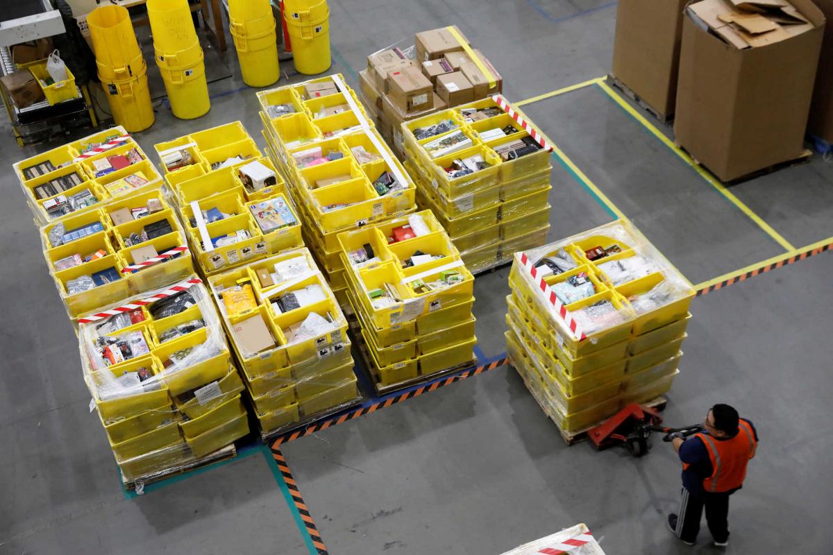 An Amazon employee works on crates of merchandise at the Amazon fulfillment center in Robbinsville