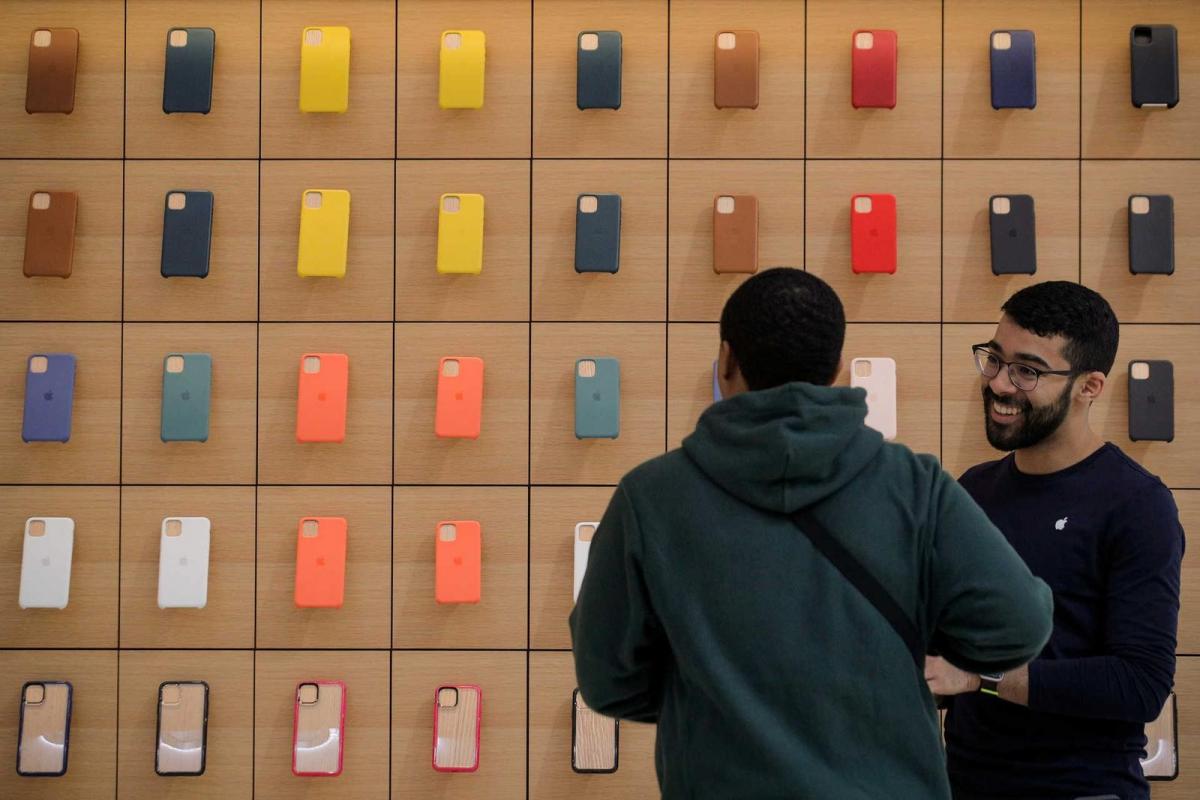 An Apple Store employee speaks to a guest during the preview of the redesigned and reimagined Apple Fifth Avenue store in New York