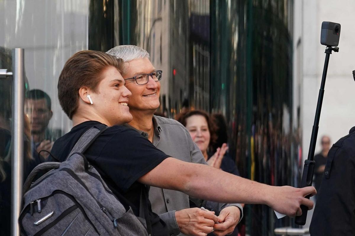 Apple CEO Tim Cook poses with fans outside the Apple Store on Fifth Ave in the Manhattan borough of New York